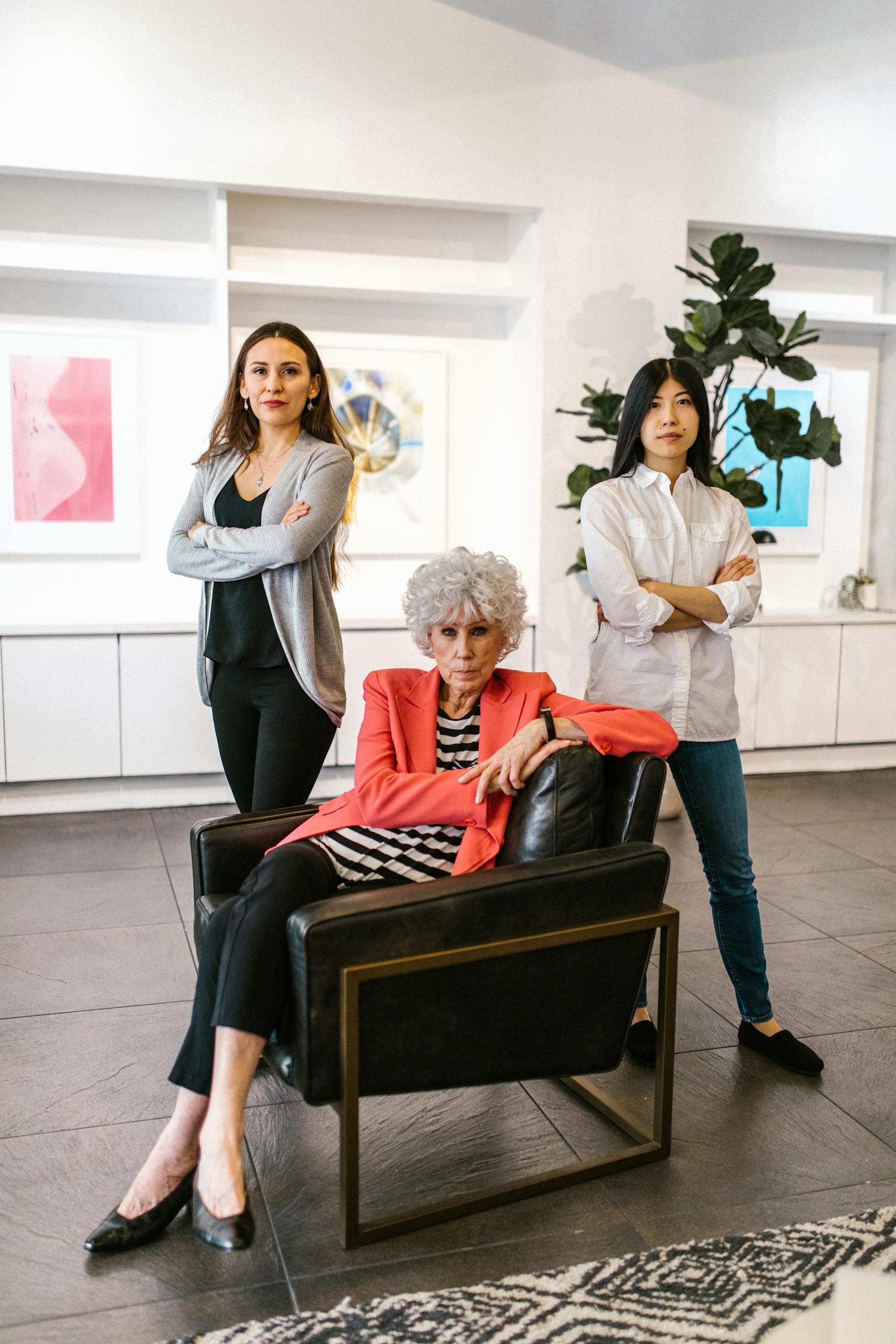Woman in White Long Sleeve Shirt Sitting on Black Leather Armchair